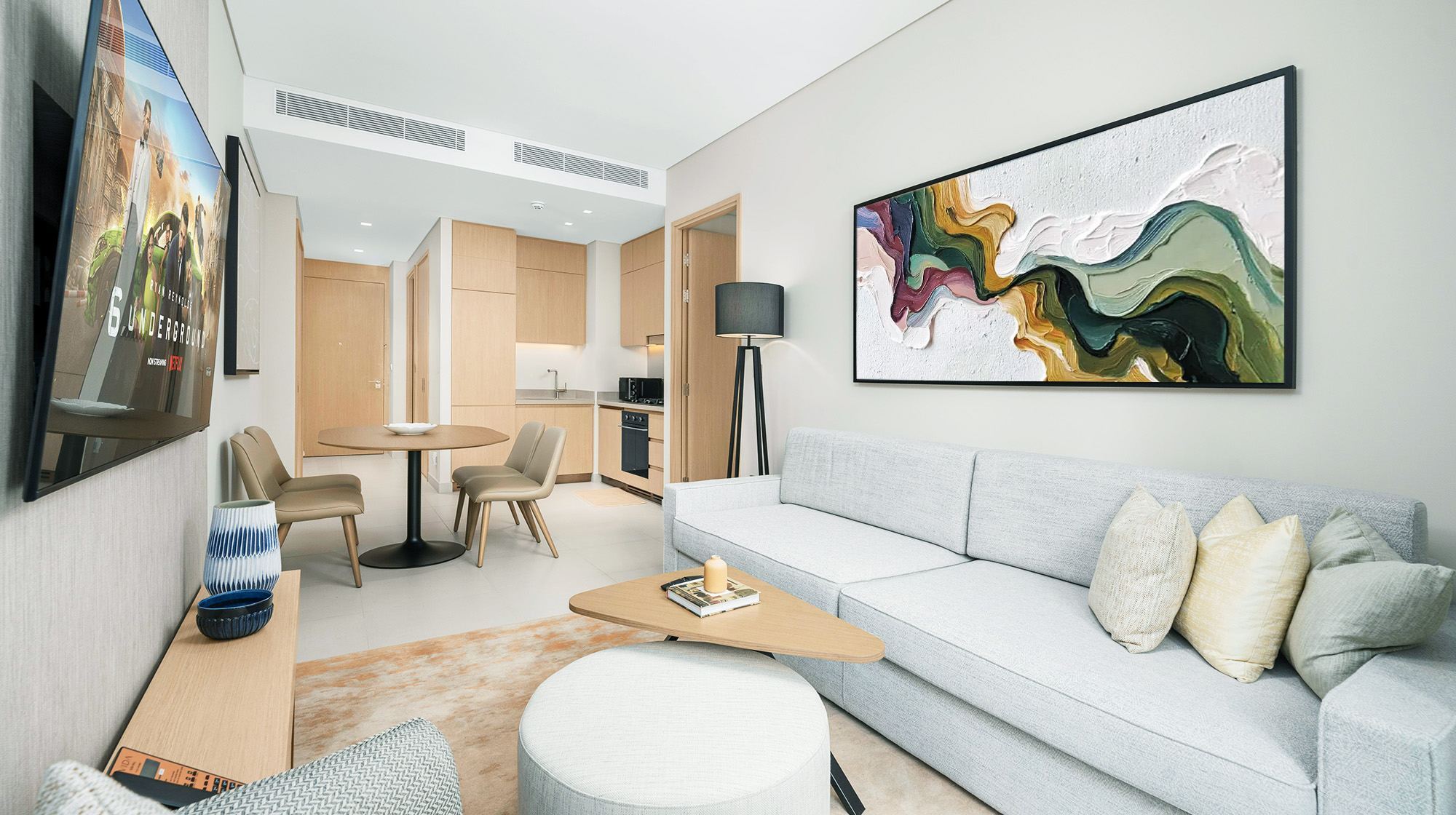 Colorful abstract wall art above a white sofa in a compact modern apartment living room.