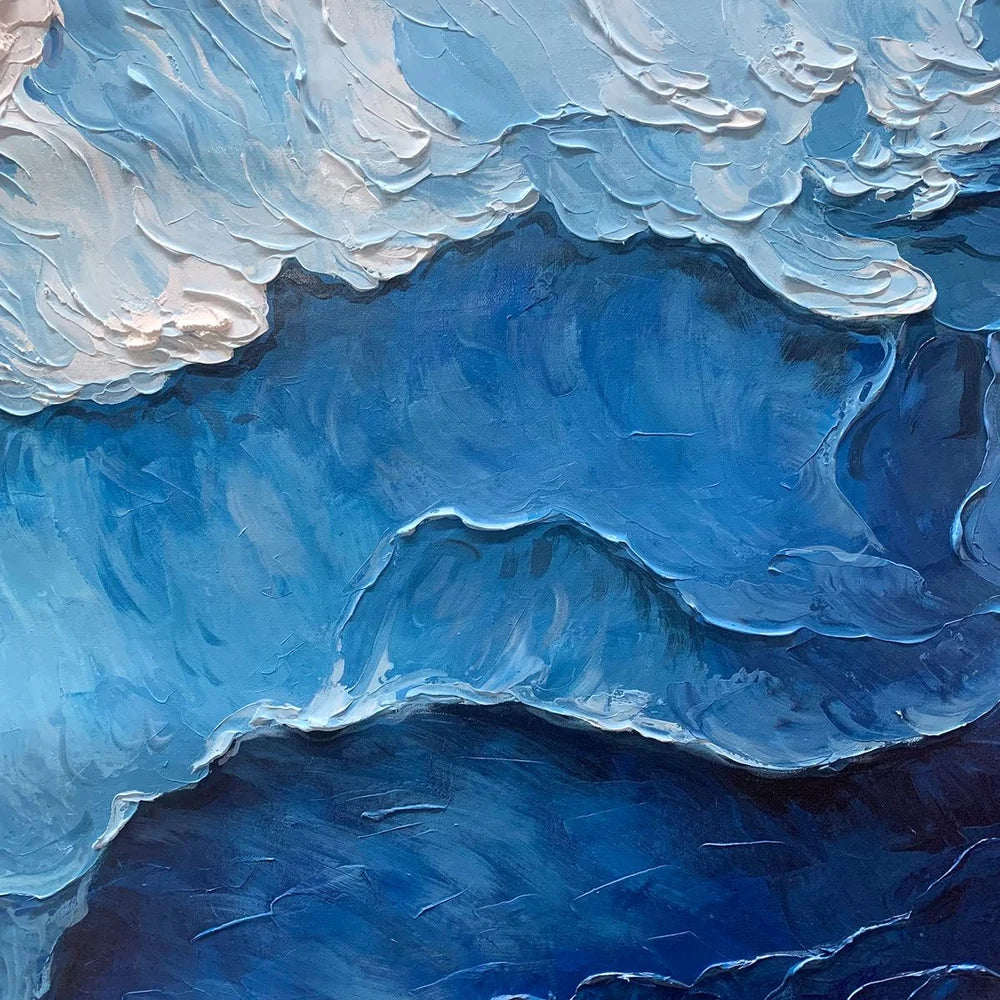 Close-up blue impasto painting shows layered wave-like strokes and thick white texture forming a dramatic ocean surface and layered brushwork.