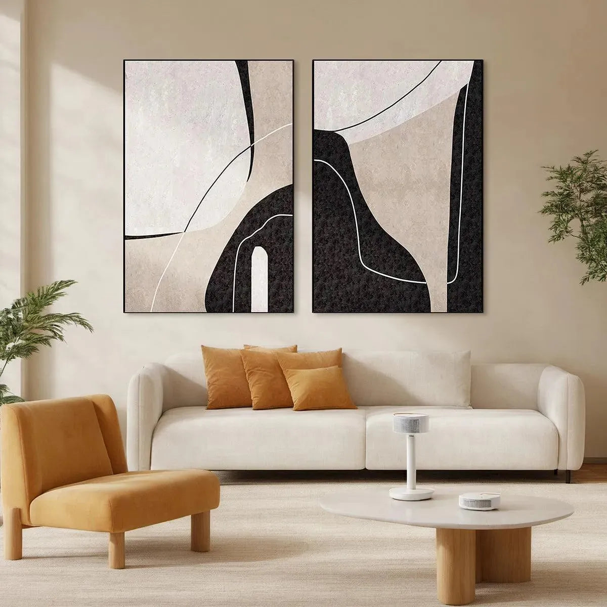 Set of 2 vertical abstract paintings in beige, black & white displayed in modern living room with cream sofa.