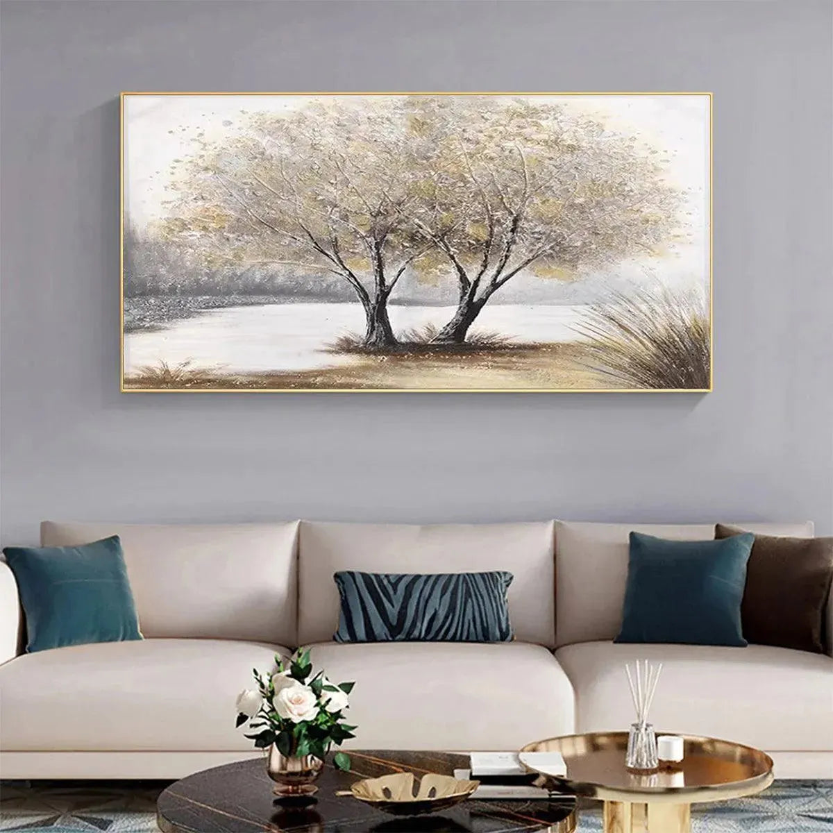 Gold-framed 'Twilight Trees' landscape painting on gray wall, complementing a cream sofa in contemporary living room decor.