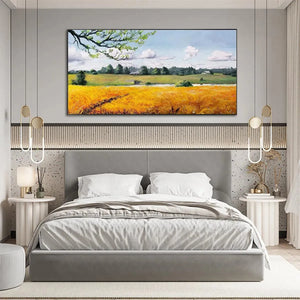 Golden Harvest landscape painting of golden field & farmhouse, displayed as wall art above bed in modern bedroom.