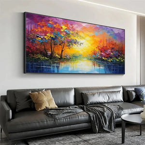 Original handmade oil painting featuring vibrant autumn trees reflected in river, displayed above grey sofa in modern living room.