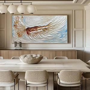 Textured white and gold angel wing painting by Liam O'Connell, horizontal impasto art in dining room context.