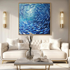 Oceanic Whirl blue fish painting in gold frame above modern white sofa, showcasing its scale in an elegant living room.