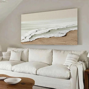 Serene Shore coastal painting by Liam O'Connell, featuring beige waves and sand; displayed in living room with white sofa.