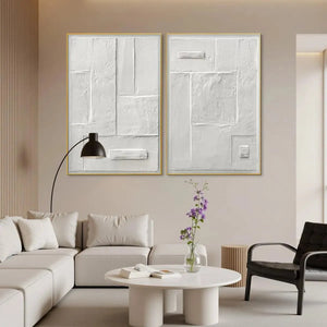 White textured diptych by Javier Ramirez, minimalist art, gold framed vertical wall art set in a living room.