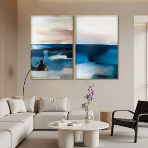 Set of 2 vertical abstract seascape paintings in blues, pinks, and beige by Willow Davies, displayed in a modern living room.