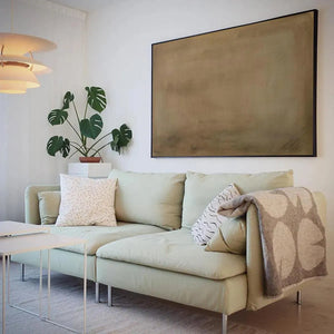 Earthy Minimalist Landscape painting by Liam O'Connell above green sofa, earthy abstract art for modern decor.