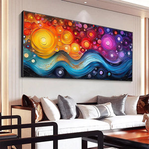 COSMIC WHIRL abstract painting: impasto yellow, orange, pink swirls above blue waves, product in lifestyle setting.