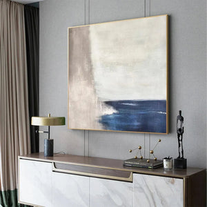 Javier Ramirez Serene Shore minimalist abstract coastal painting, blue and beige tones, gold frame, modern home decor