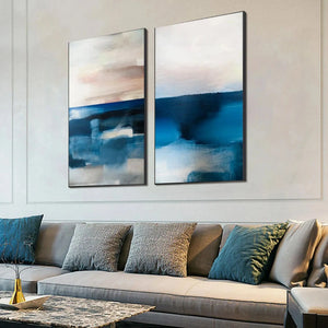 Willow Davies Abstract Ocean Diptych: two vertical blue, pink, beige seascape paintings above gray sofa.