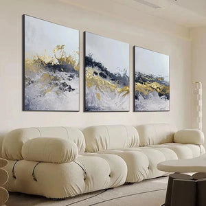 Gold and Grey Abstract Triptych: Textured impasto painting set of 3 vertical canvases above a cream sofa.