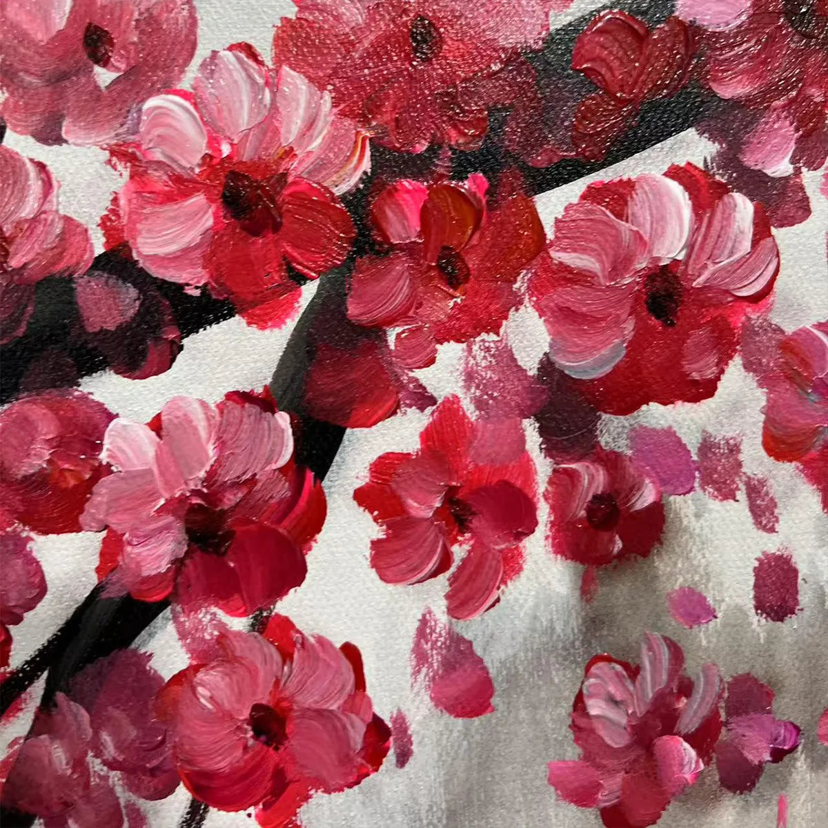 Close up of Chen Liu's original oil painting, thick, textured red and pink cherry blossoms on a white canvas.