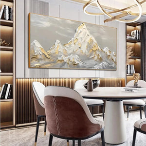 Textured impasto painting of gold and grey snow-capped mountains in a modern dining room.