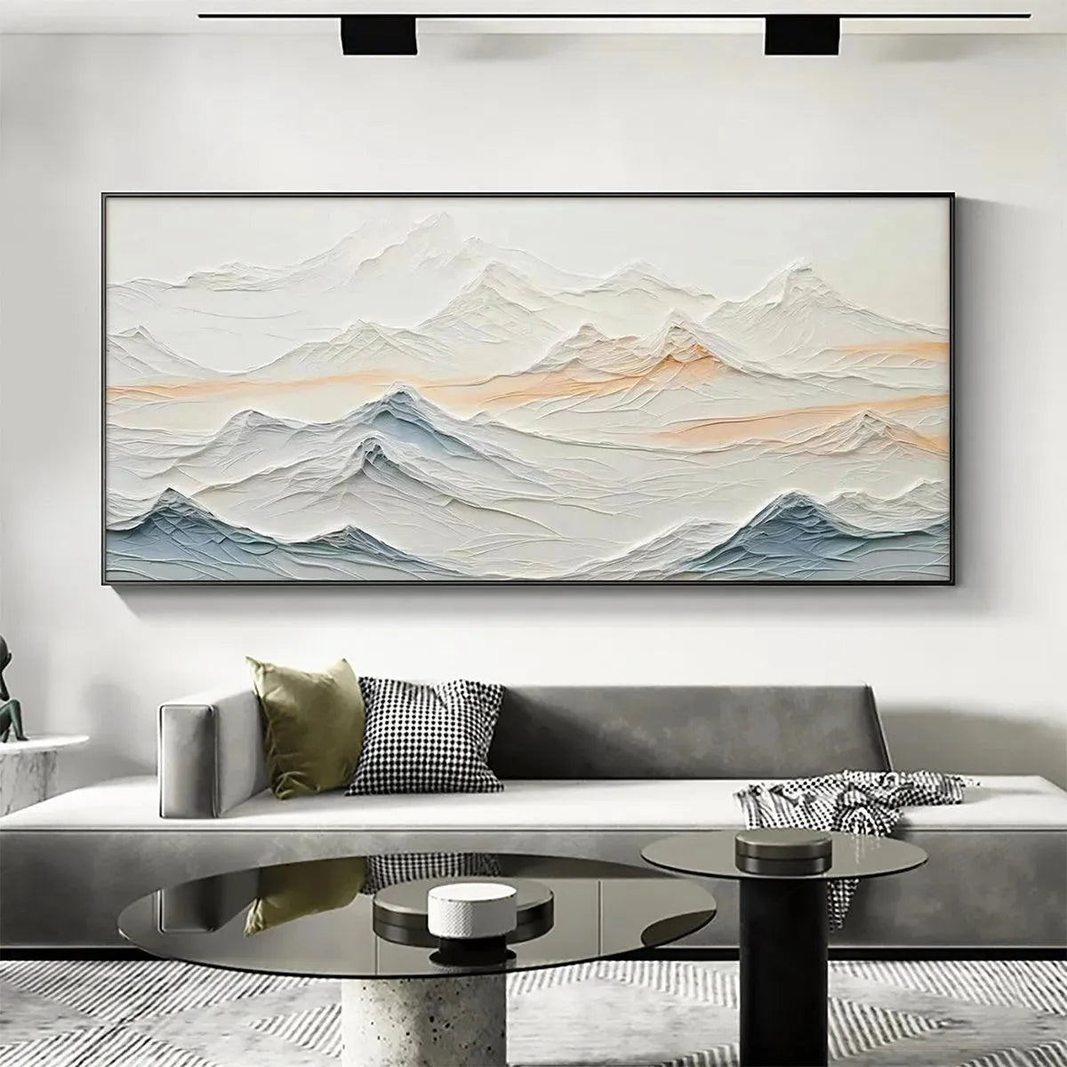 Textured abstract mountain painting in beige, blue, and peach hues, displayed above a modern sofa in a living room setting.
