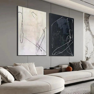 Javier Ramirez minimalist black & white abstract art duo in black frames, styled in a living room.