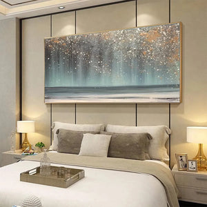 AURORA DUST: Horizontal abstract ocean painting with gold speckles above bed in modern bedroom. Textured blues, greys, gold.