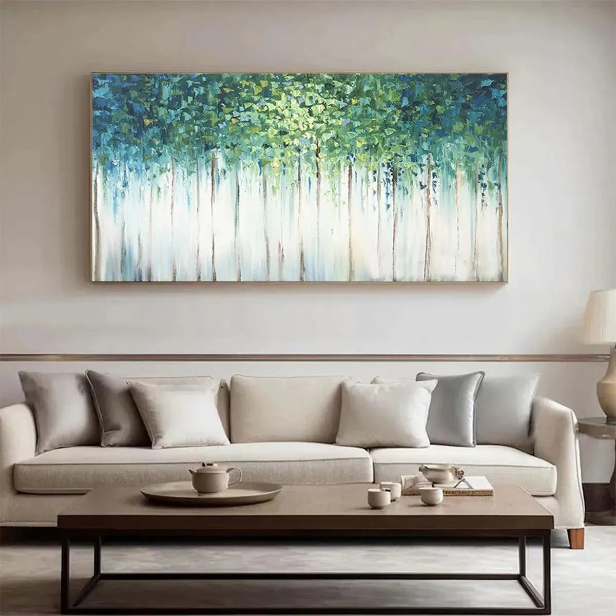 EMERALD FOREST abstract painting, green & blue forest artwork with light trunks, adorning a modern living room above a sofa.