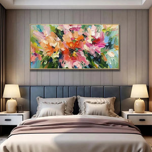 Vibrant Blushing Blooms impasto floral art in pink & orange, gold framed, complementing a modern bedroom's dark blue bed.
