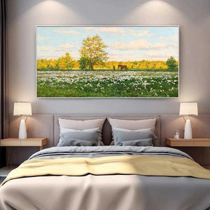 Tranquil Sunlit Meadow painting with white flowers, horse, & figure, displayed above a bed in a modern bedroom.
