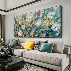 Elodie Dubois Golden Garden painting displayed above a sofa. Textured white flowers, gold and teal leaves with pink accents.