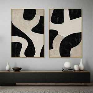 Black and beige abstract diptych with organic geometric shapes in gold frames, minimalist wall art.