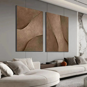 Set of 2 brown textured abstract paintings with curved designs above sectional sofa in modern living room