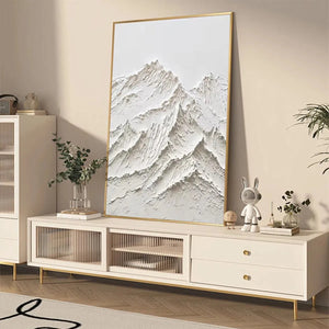 Textured white mountain painting by Liam O'Connell, impasto style with gold frame, shown in a living room.