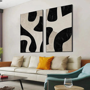 Black and beige vertical abstract art set of 2 with organic shapes, shown in a modern living room.