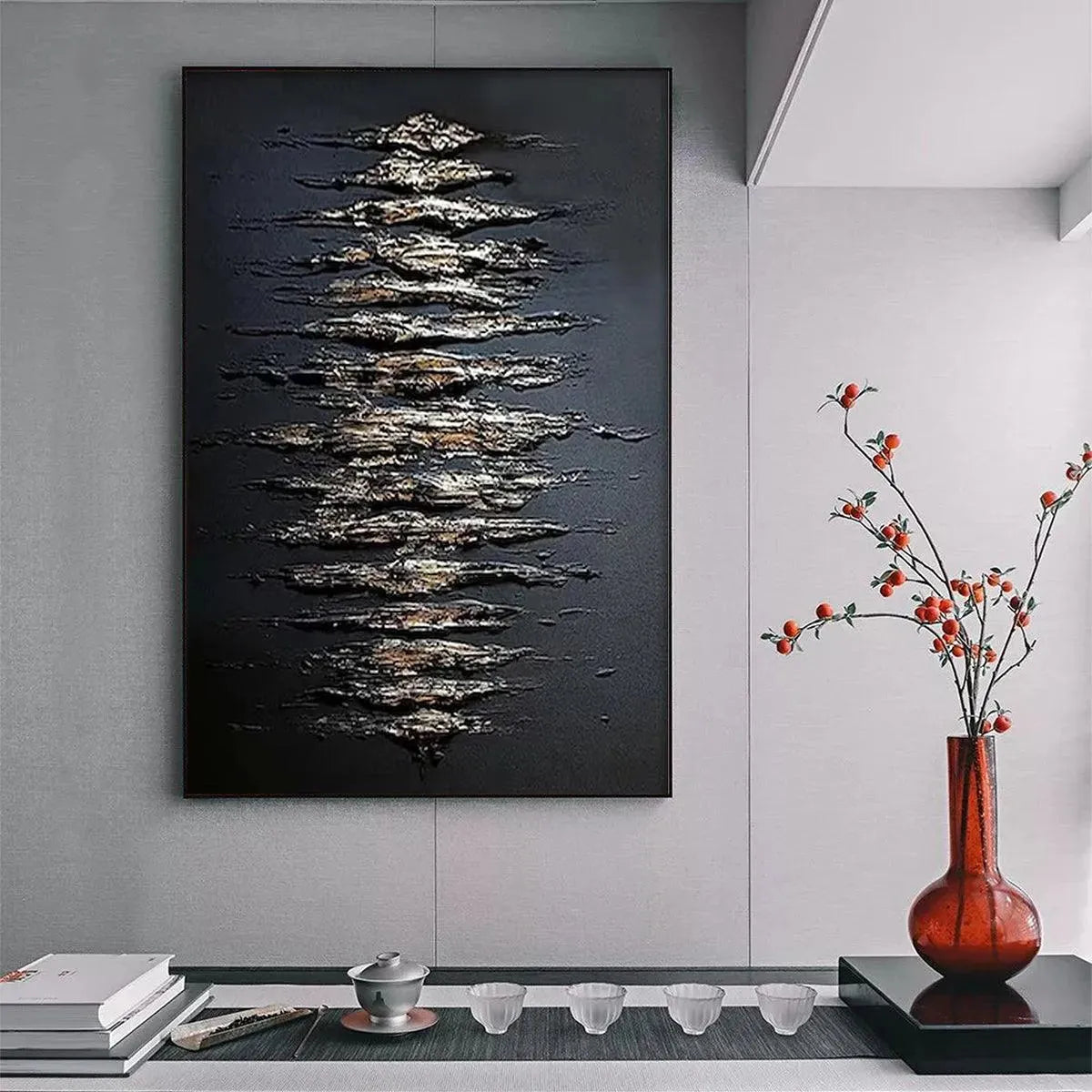 Textured black and gold abstract painting with raised impasto strokes in a modern living room setting.