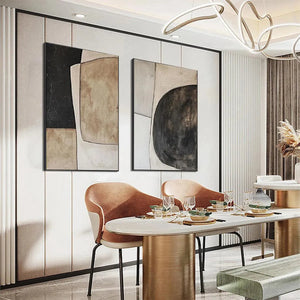 Abstract geometric diptych wall art set of 2 in black, beige, brown displayed above a dining table.