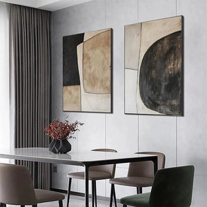Abstract geometric diptych wall art set in black, beige, and brown, displayed above a dining table.