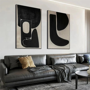 Set of 2 black and beige abstract vertical paintings by Javier Ramirez, displayed above a grey sofa.