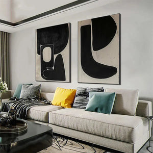 Black and beige abstract diptych wall art set displayed in a modern living room above a sofa.
