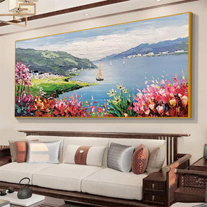 Gold-framed impressionist coastal painting, vibrant flowers & sailboat, perfect decor for a modern living room.