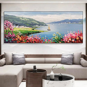 Elodie Dubois' Seaside Charm Impressionist coastal painting: vibrant flowers, bay, sailboat, above a modern living room sofa.