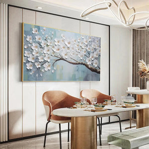 White Blossoms textured floral oil painting with gold frame in modern dining room above round table.