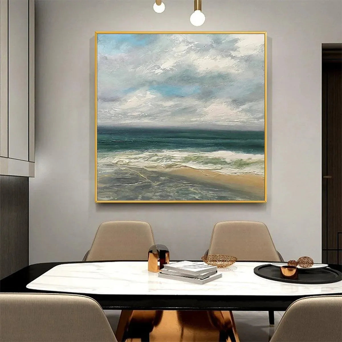 Textured cloudy coastal seascape in gold frame, soft gray and teal ocean painting above dining table.
