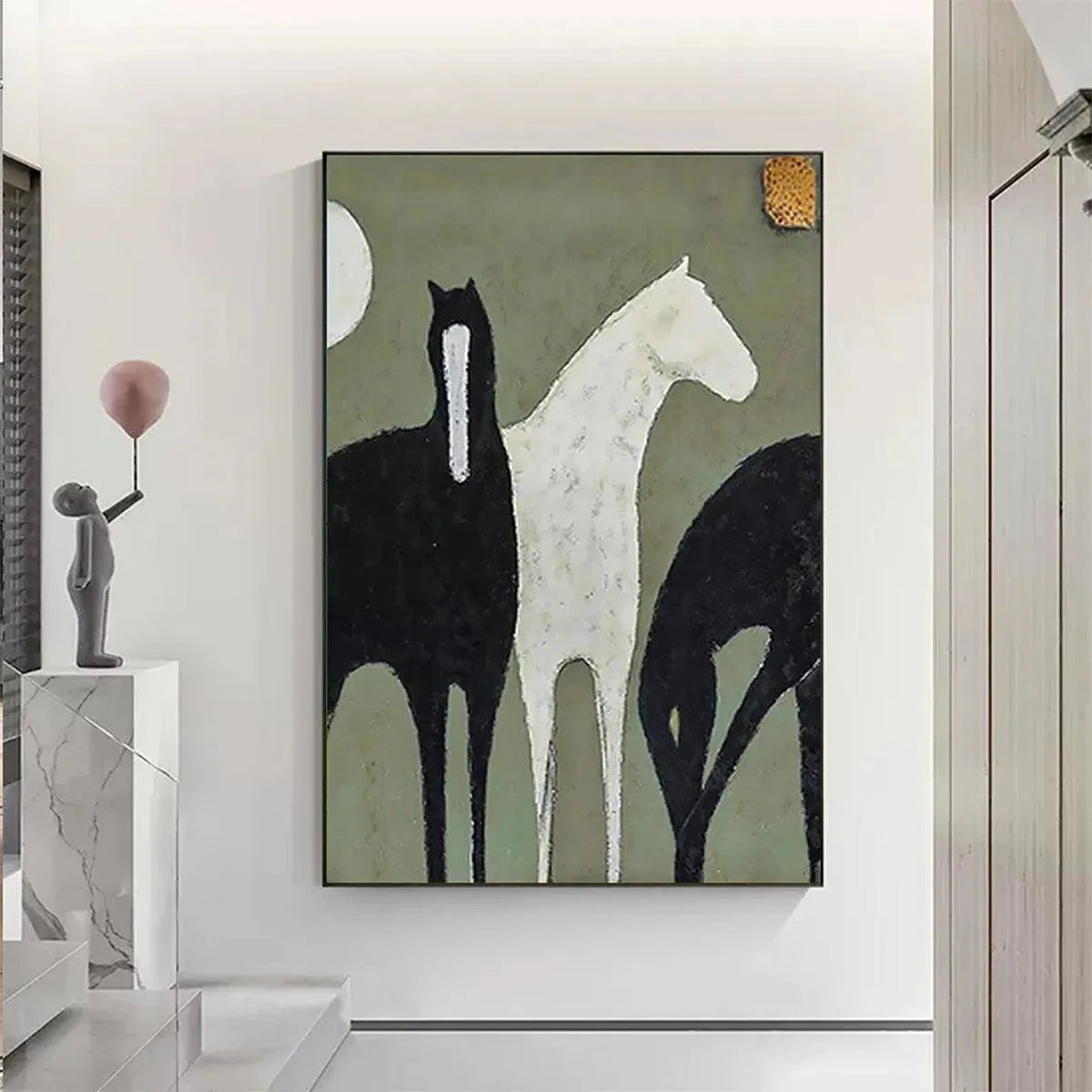 Minimalist vertical painting featuring three horses, one white and two black, on a sage green background, framed.