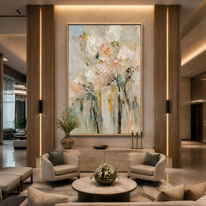 Pastel floral bouquet painting with textured petals in a gold frame displayed in a luxury hotel lobby.