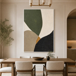 Modern organic abstract wall art with green, beige, black and white shapes in a gold frame displayed in a refined dining room.
