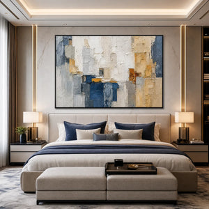 Textured abstract cityscape impasto painting in blue, white and gold above a modern bedroom bed