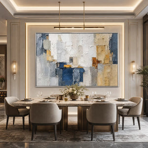 Textured abstract cityscape painting in blue, white, and gold above a luxury dining table