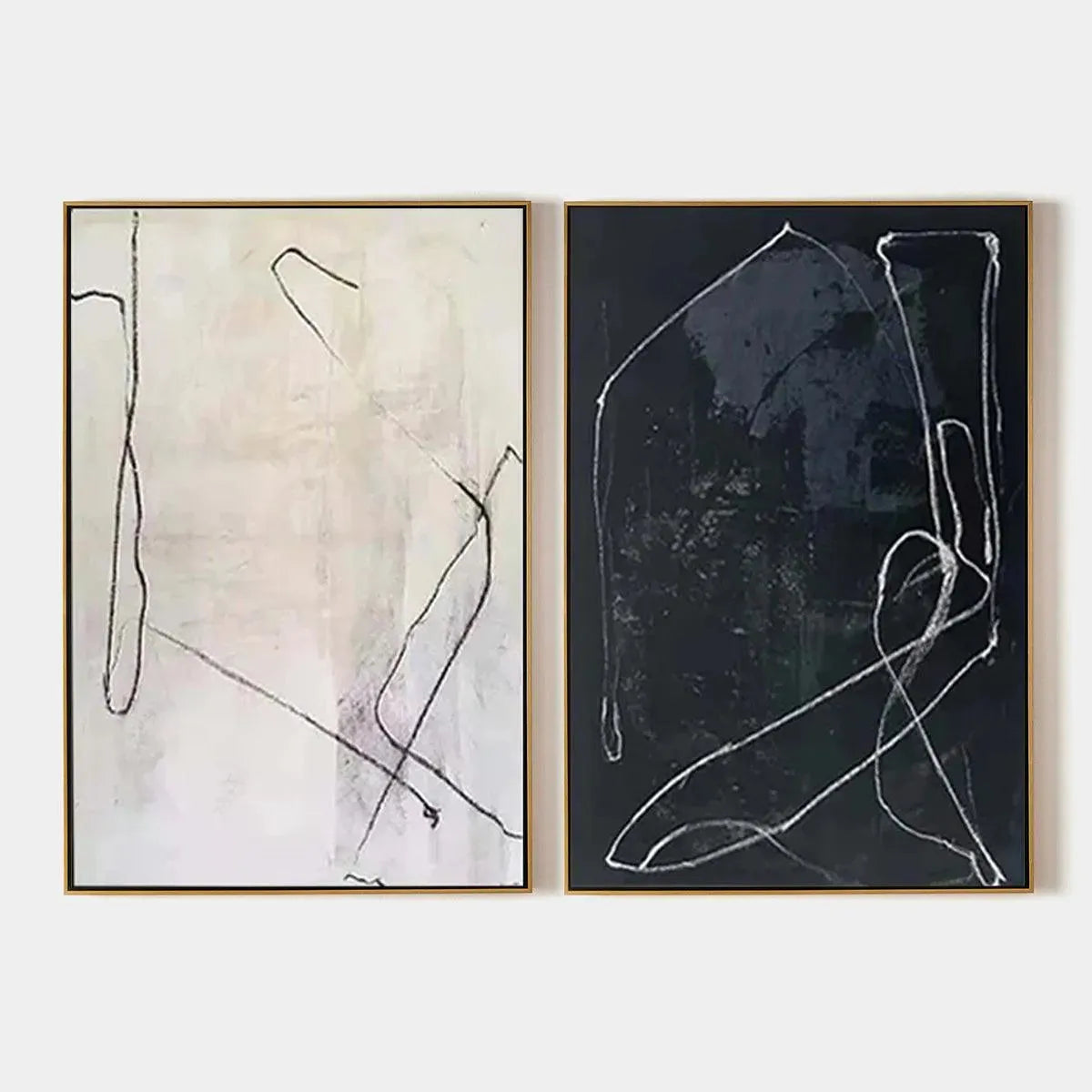 Two minimalist abstract line art paintings in black and white with gold frames, vertical orientation.