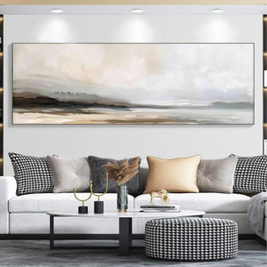 Liam O'Connell's panoramic misty mountain lake landscape painting in muted earth tones above a white sofa.