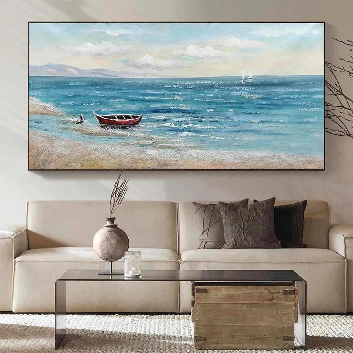 Red Boat at the Shore coastal landscape painting mounted above a cream sofa, perfect for modern living room decor.