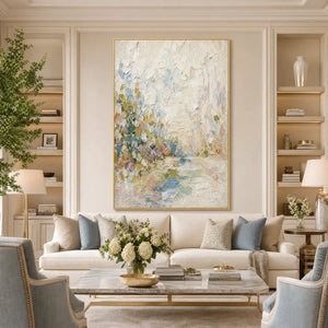 Textured abstract landscape oil painting in soft white, blue, and green above a cream sofa