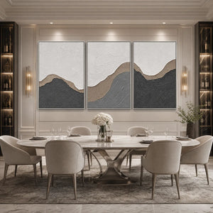 Textured earth-tone abstract triptych wall art above modern dining table