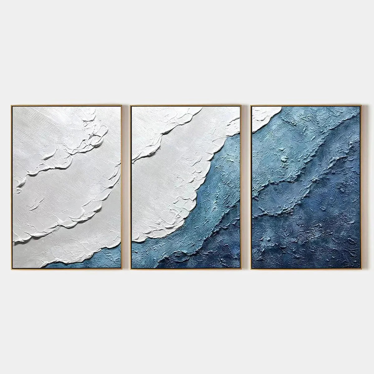 Textured abstract triptych painting set in shades of blue and white, framed in gold, evoking ocean waves.