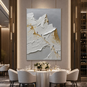 Textured abstract mountain impasto oil painting in white, gold and gray above dining table